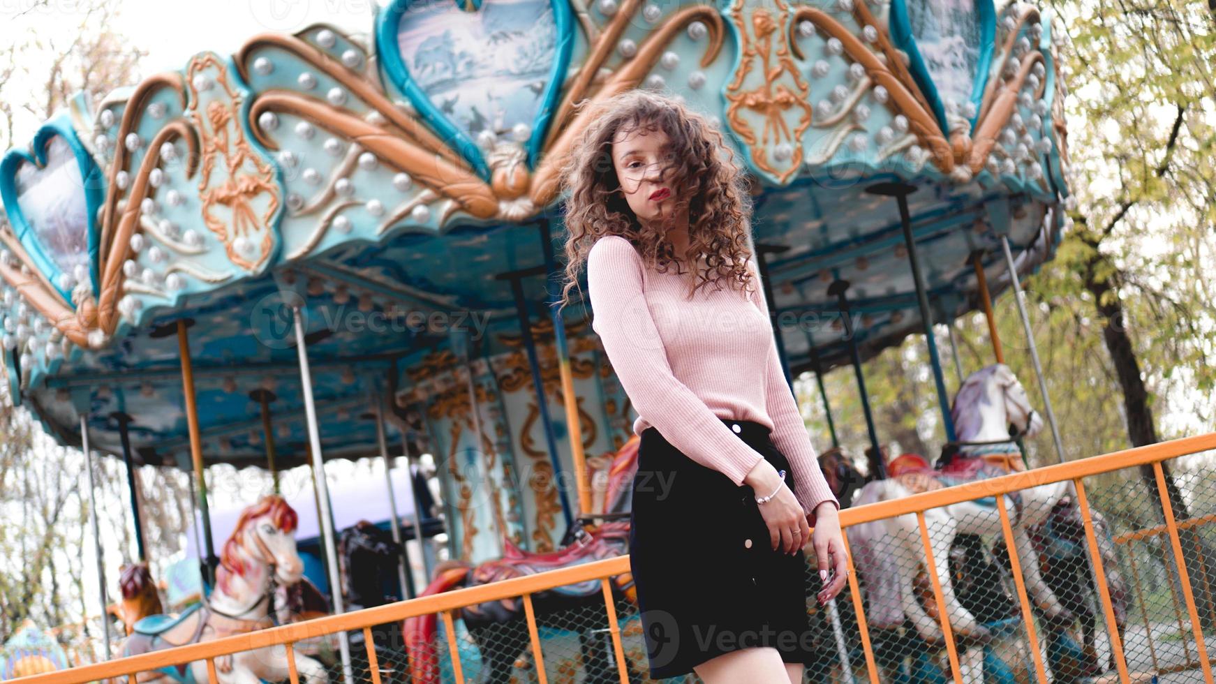 mulher jovem hippie posando ao ar livre no fundo de carrosséis foto