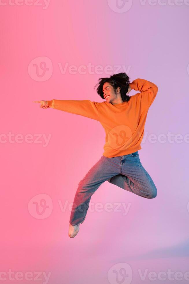 imagem do uma jovem ásia pessoa dançando em uma néon colori fundo foto