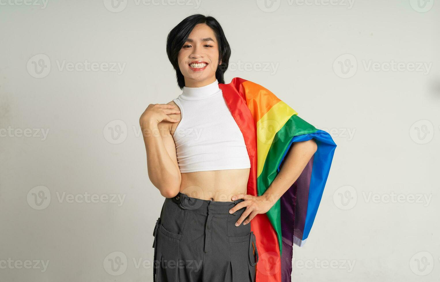 imagem do ásia gay homem segurando uma arco Iris bandeira com confiança posando em uma branco fundo foto