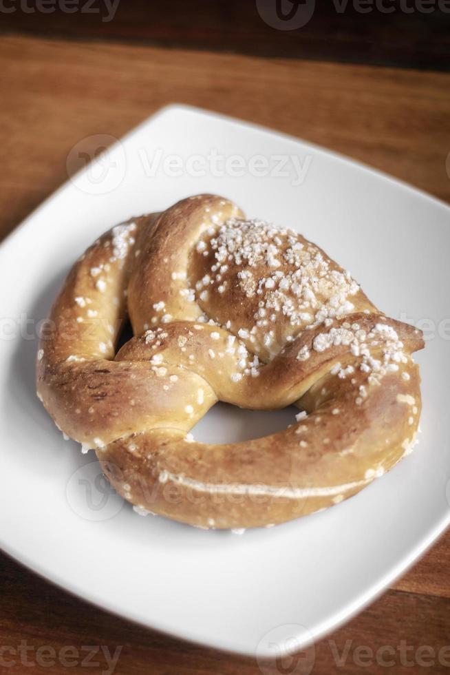 Pão de pretzel tradicional alemão orgânico sem laticínios vegan em mesa de madeira foto