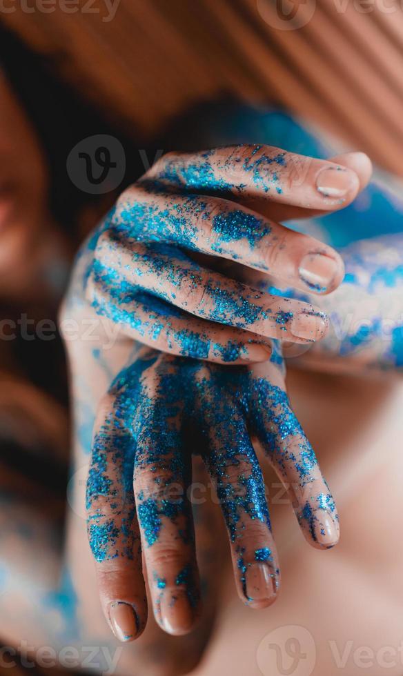 glitter azul nas mãos da mulher. movimentos suaves das mãos foto