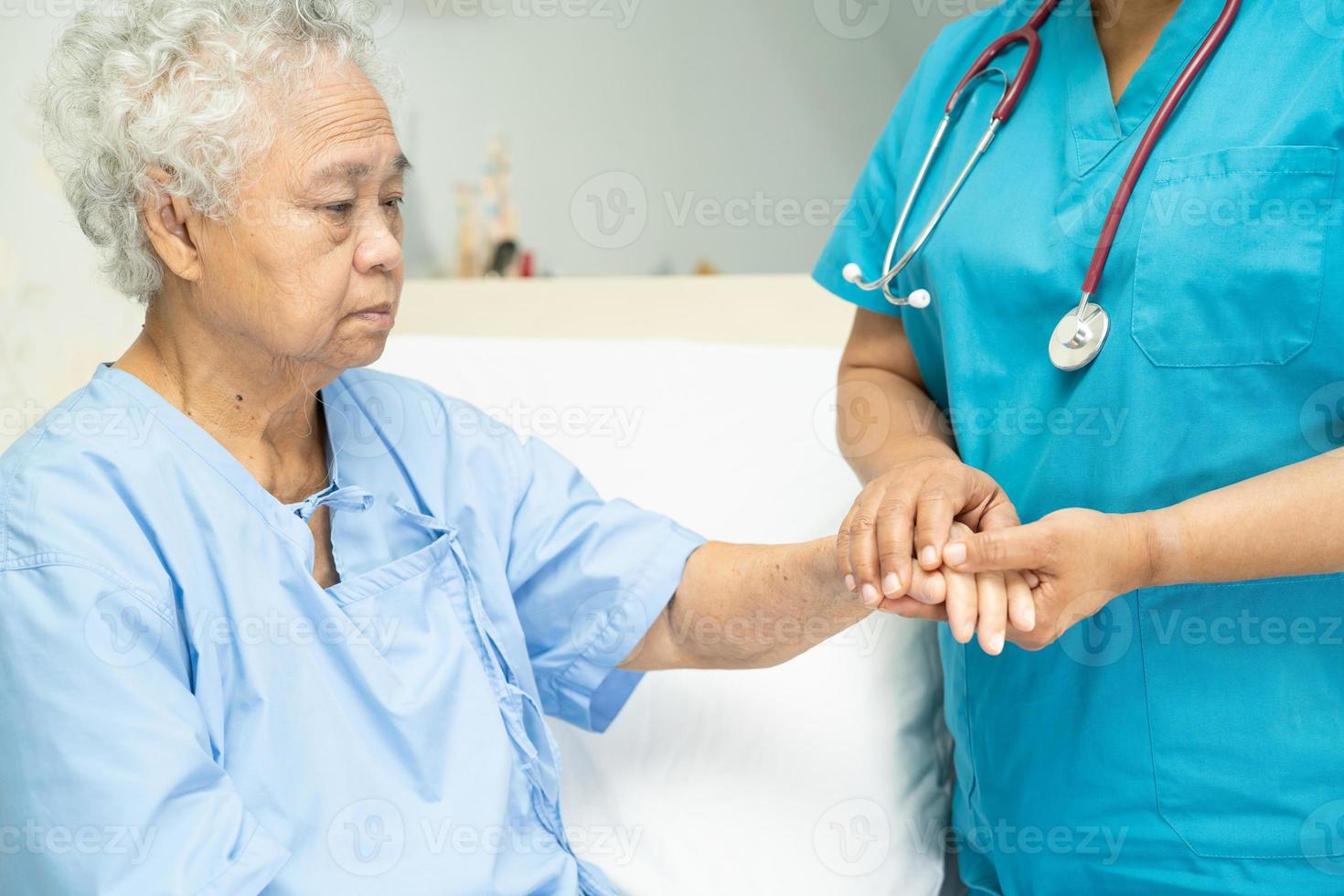 tocando paciente idosa asiática com amor foto