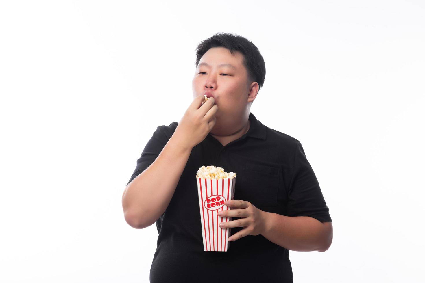 jovem asiático gordo engraçado comendo pipoca foto