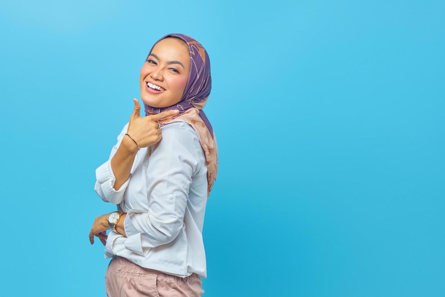 linda mulher asiática sorrindo e apontando para o espaço vazio foto