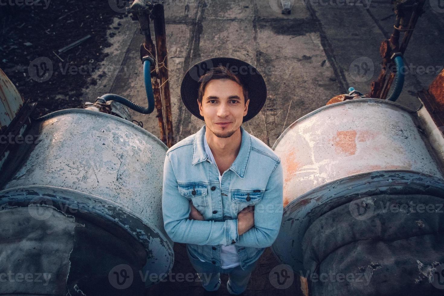 homem com chapéu vestindo camisa branca e calça jeans no fundo da cidade foto