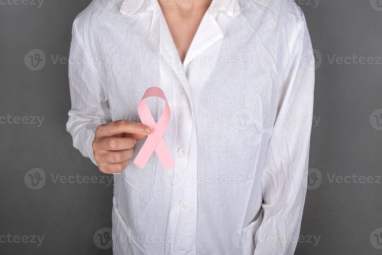 médico segurando um símbolo de fita rosa da luta contra o câncer de mama. foto