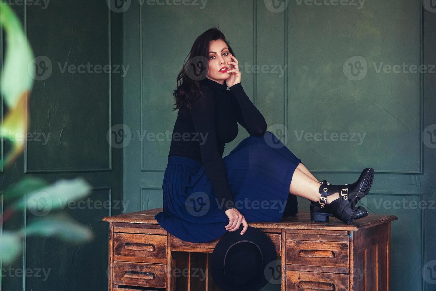 mulher posando em uma mesa de madeira foto