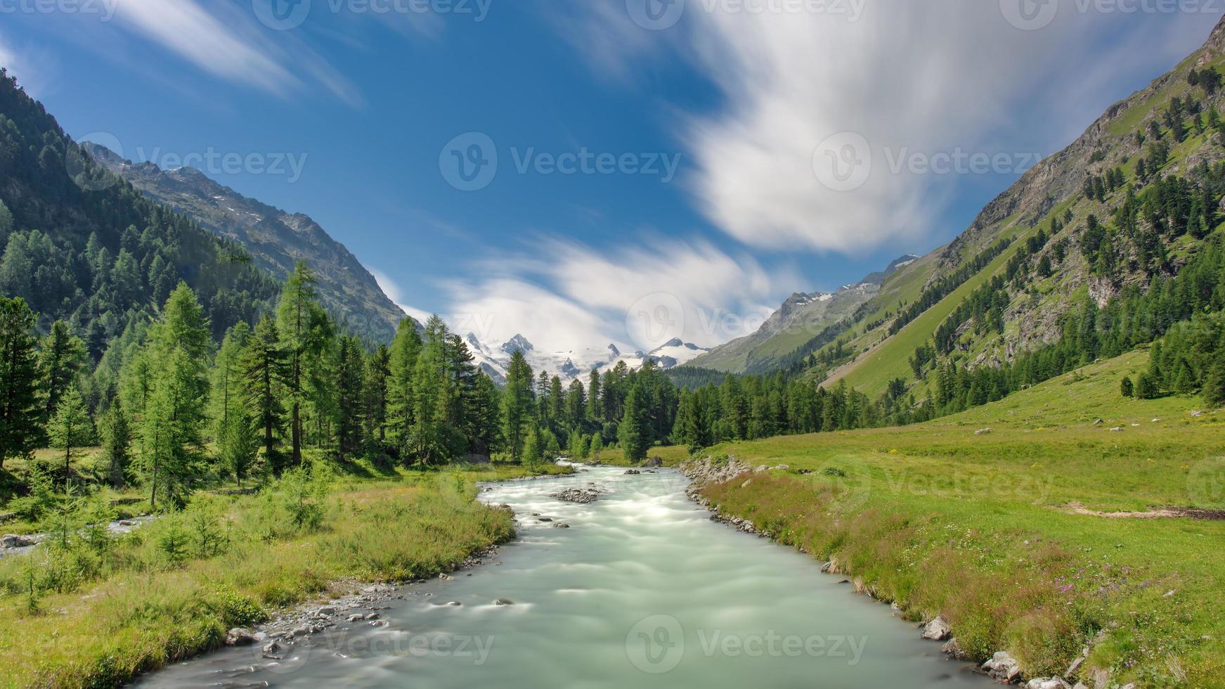 rio fluindo de uma geleira nos Alpes suíços foto