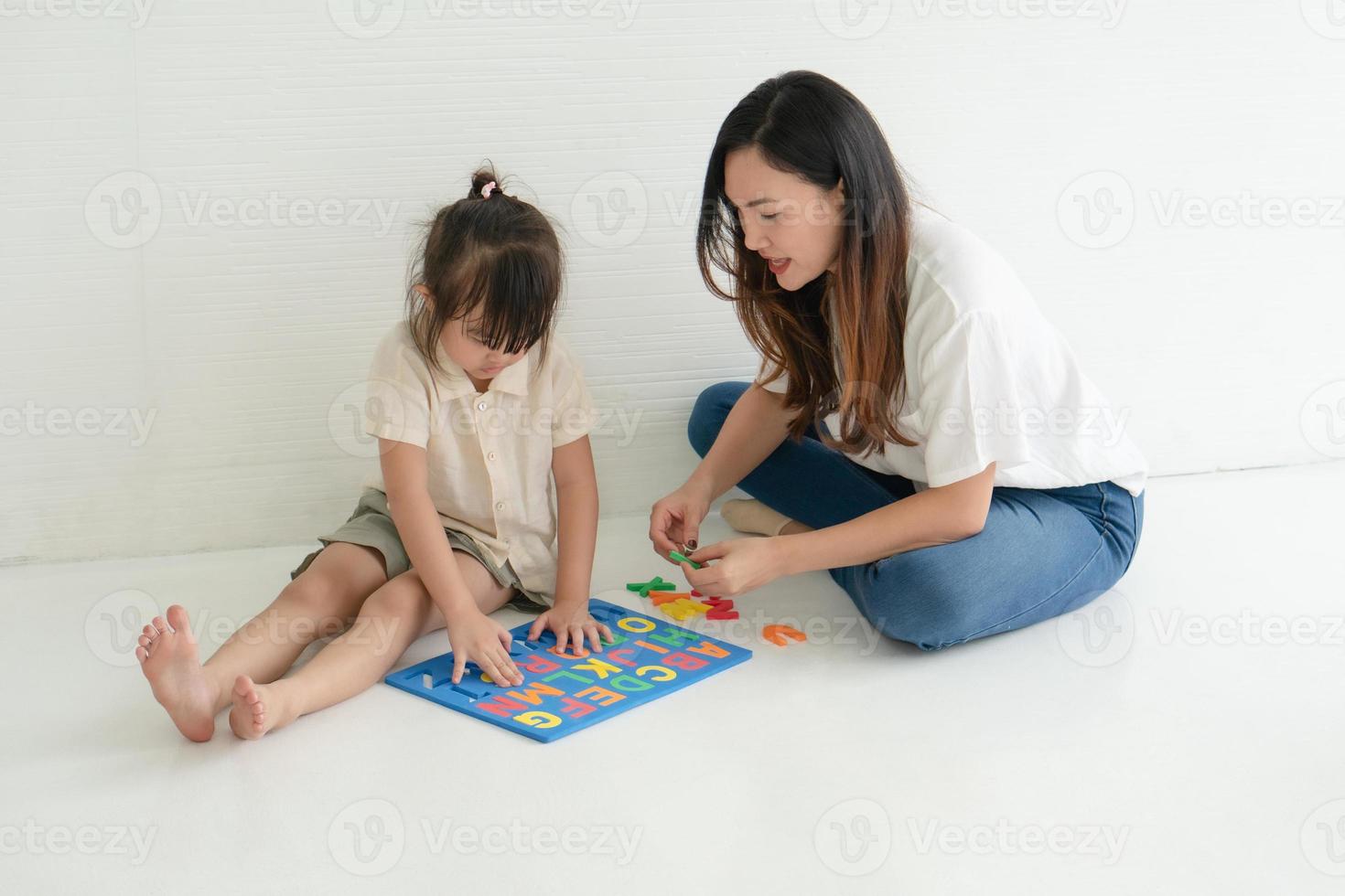 mãe e filho brincando com um quebra-cabeça foto