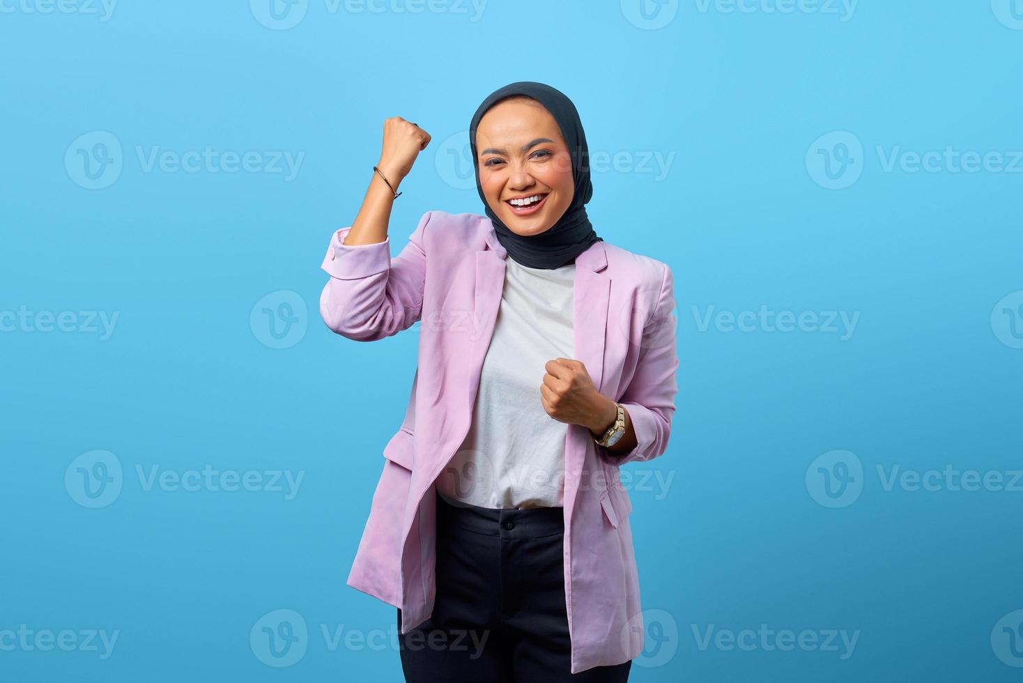 Mulher asiática animada comemorando a sorte e fazendo gesto de vitória foto