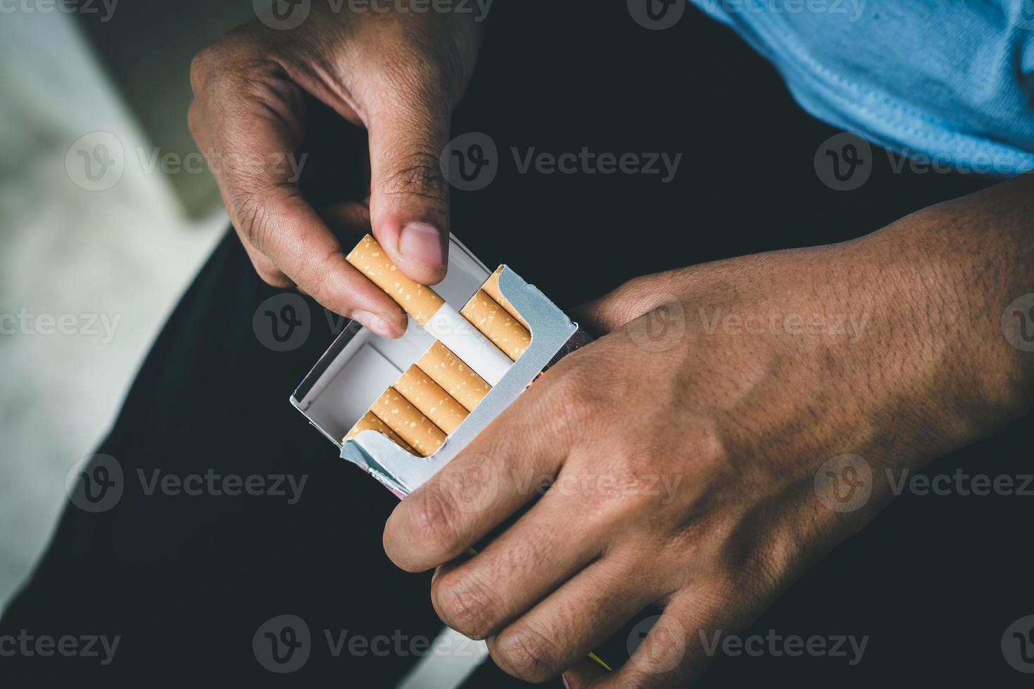 feche a mão do homem segurando retire o cigarro foto