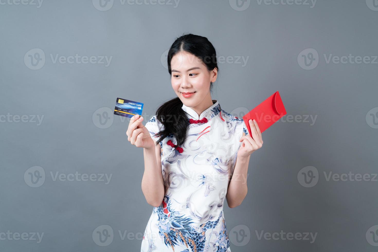 mulher asiática usa vestido tradicional chinês com envelope vermelho foto