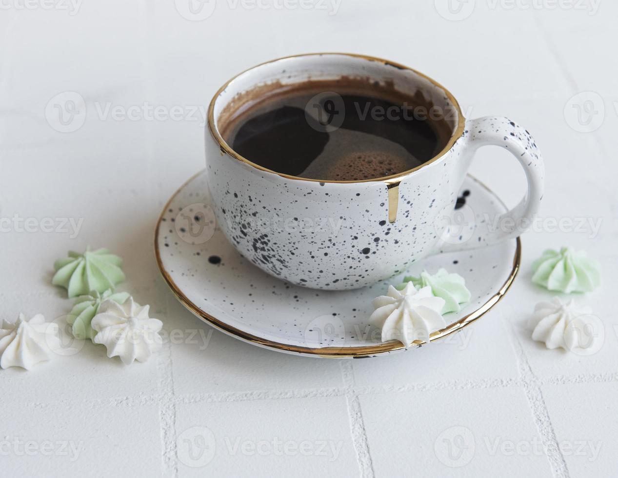 xícara com café e pequenos merengues foto