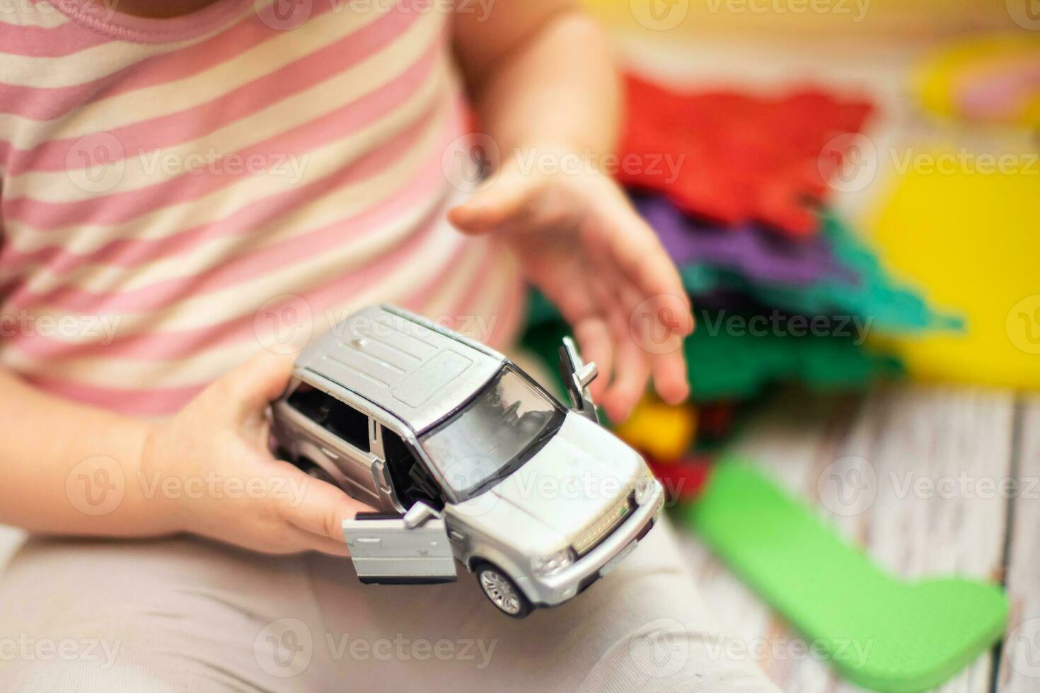 criança abre porta para cinzento minivan. desenvolvimento do bem motor Habilidades dentro crianças. jogos dentro Jardim da infância. foto