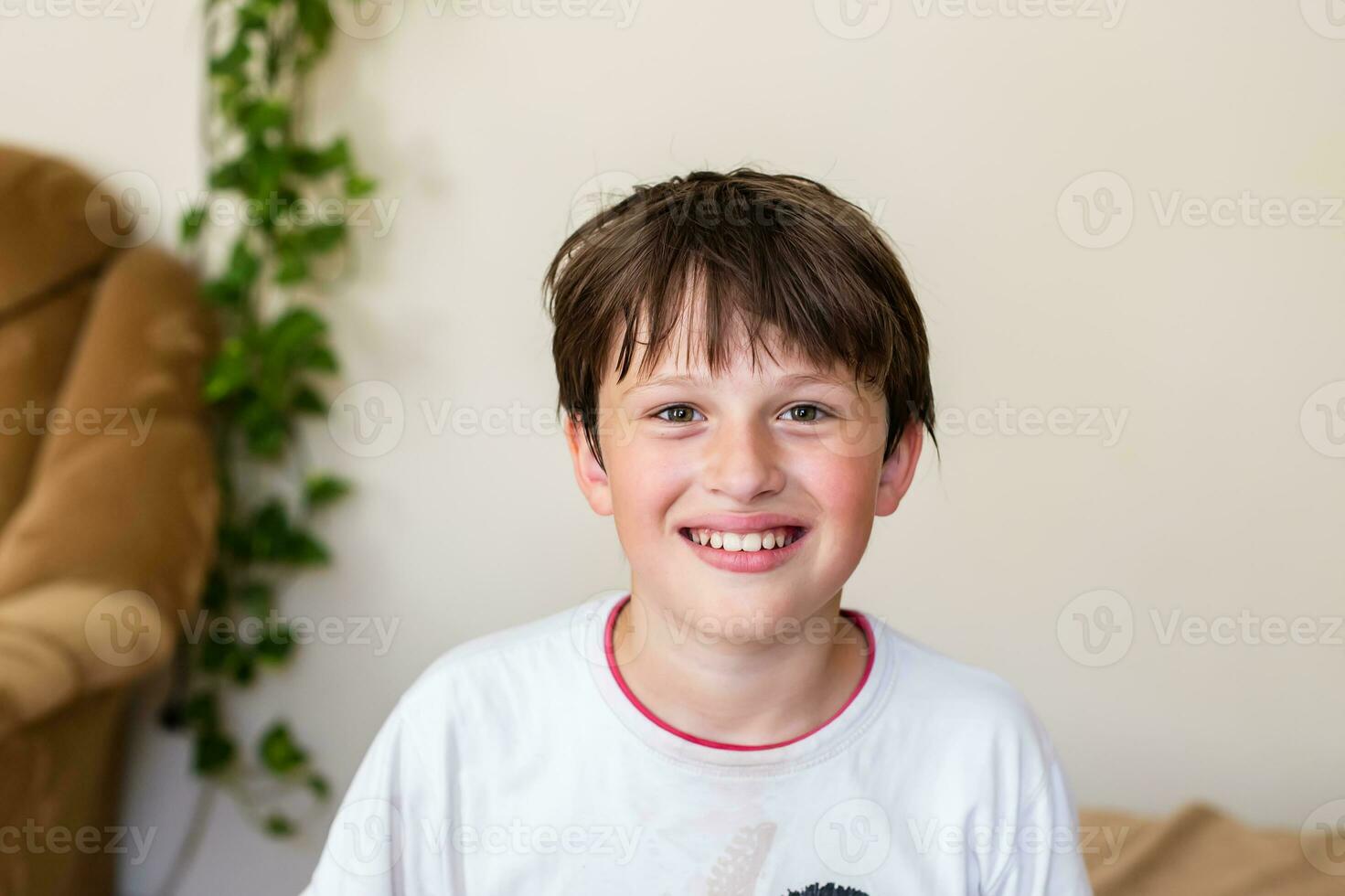 retrato do sorridente adolescente Garoto olhando às Câmera às lar. criança rindo foto