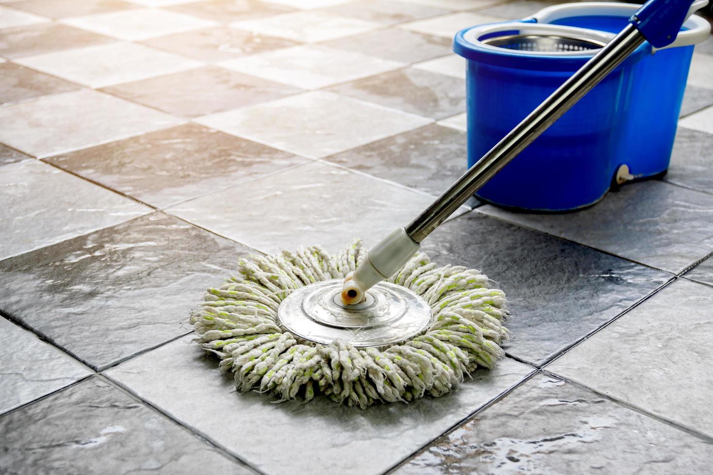 Limpe o piso de cerâmica com esfregões e produtos de limpeza de piso. foto