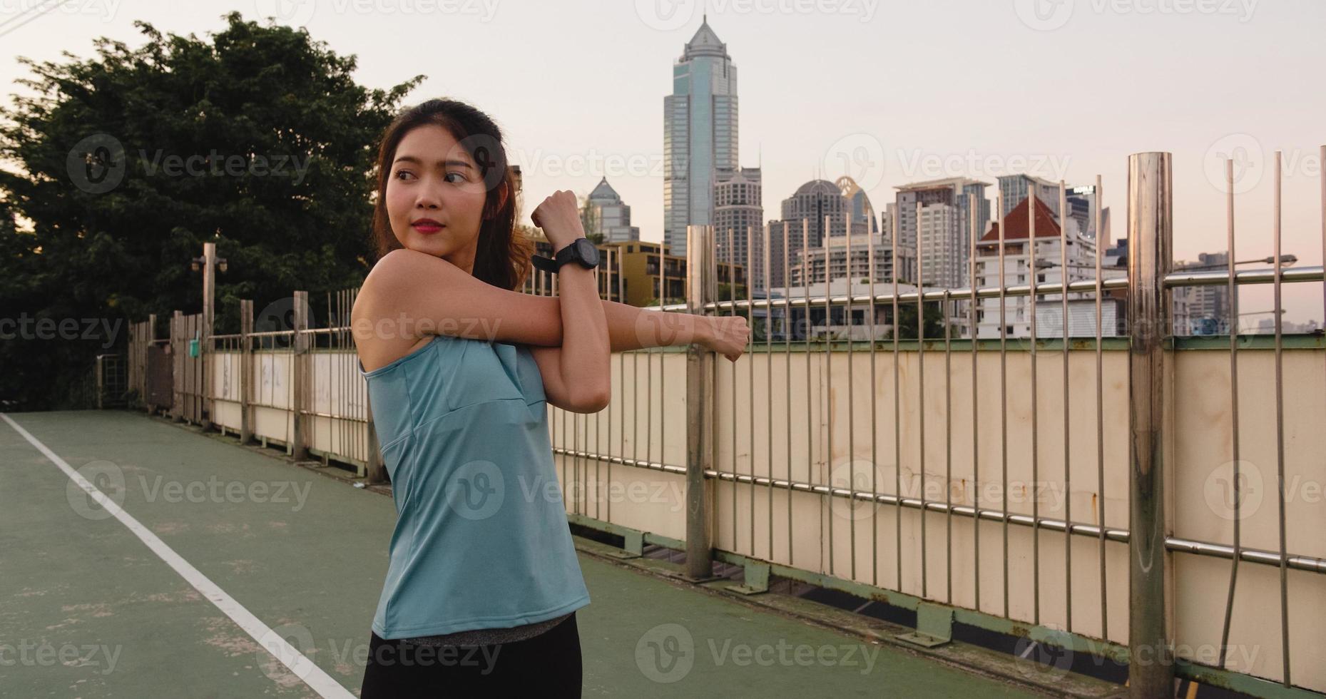 Ásia atleta senhora exercícios fazendo alongamento em urbano. foto