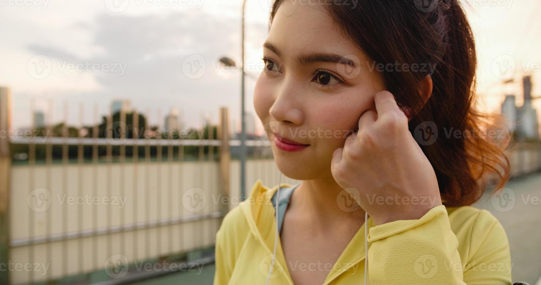 Ásia atleta senhora exercícios usando smartphone para ouvir música. foto