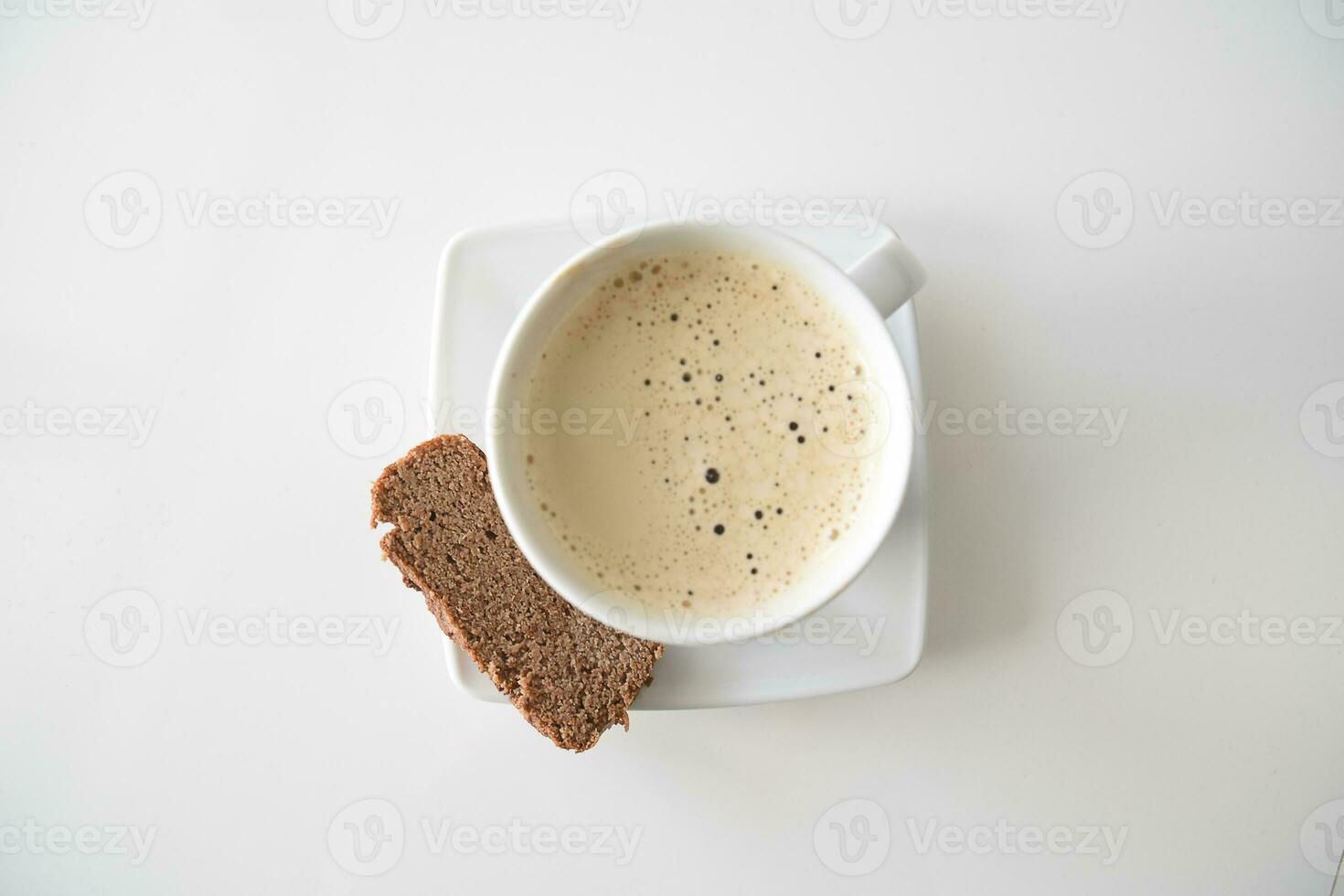 café com leite dentro uma branco caneca com uma livre de glúten banana pão em uma luz suave fundo foto