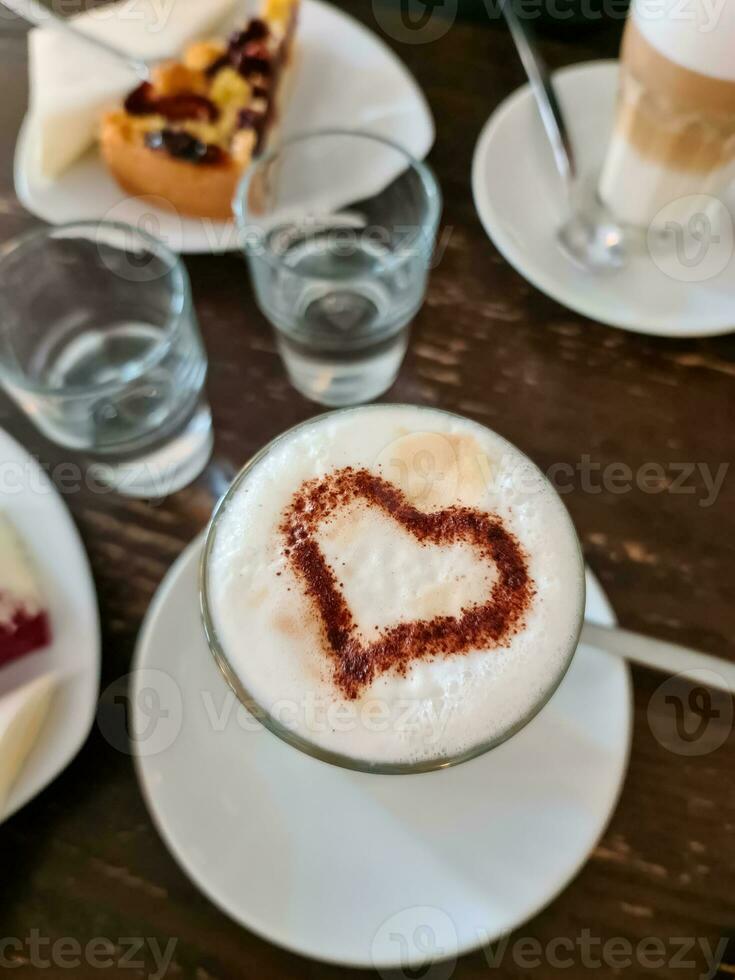 uma saboroso café com leite e uma coração do chocolate em isto foto