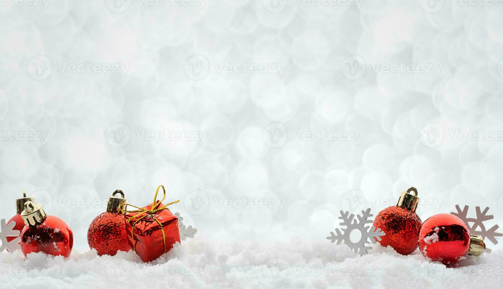 cumprimento Natal decorações vermelho brinquedos bolas em a neve espumante prata fundo bandeira com cópia de espaço foto