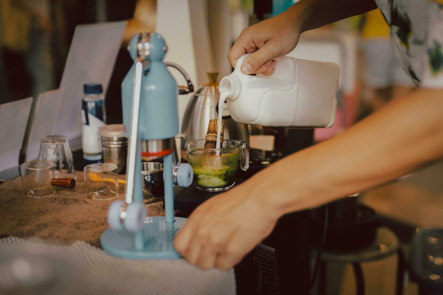 barista preparando matcha café com leite com mão derramando leite dentro cafeteria. foto