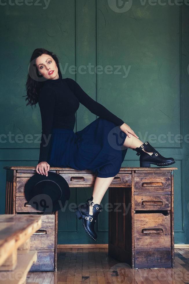 mulher posando em uma mesa de madeira foto