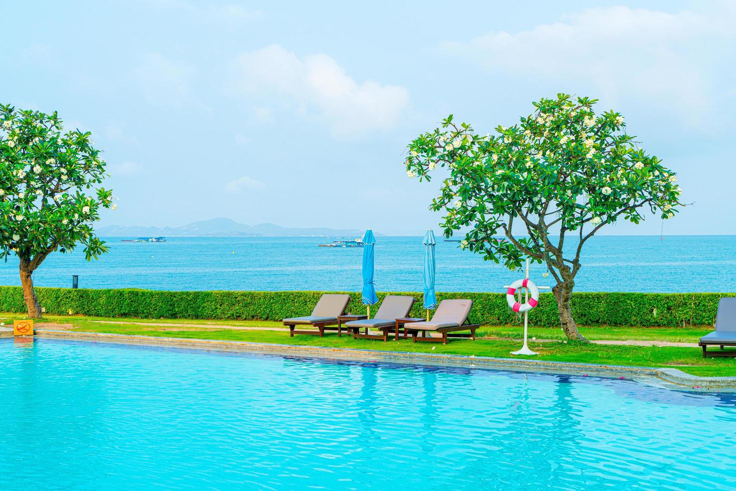 cadeira, piscina e guarda-sol ao redor da piscina foto