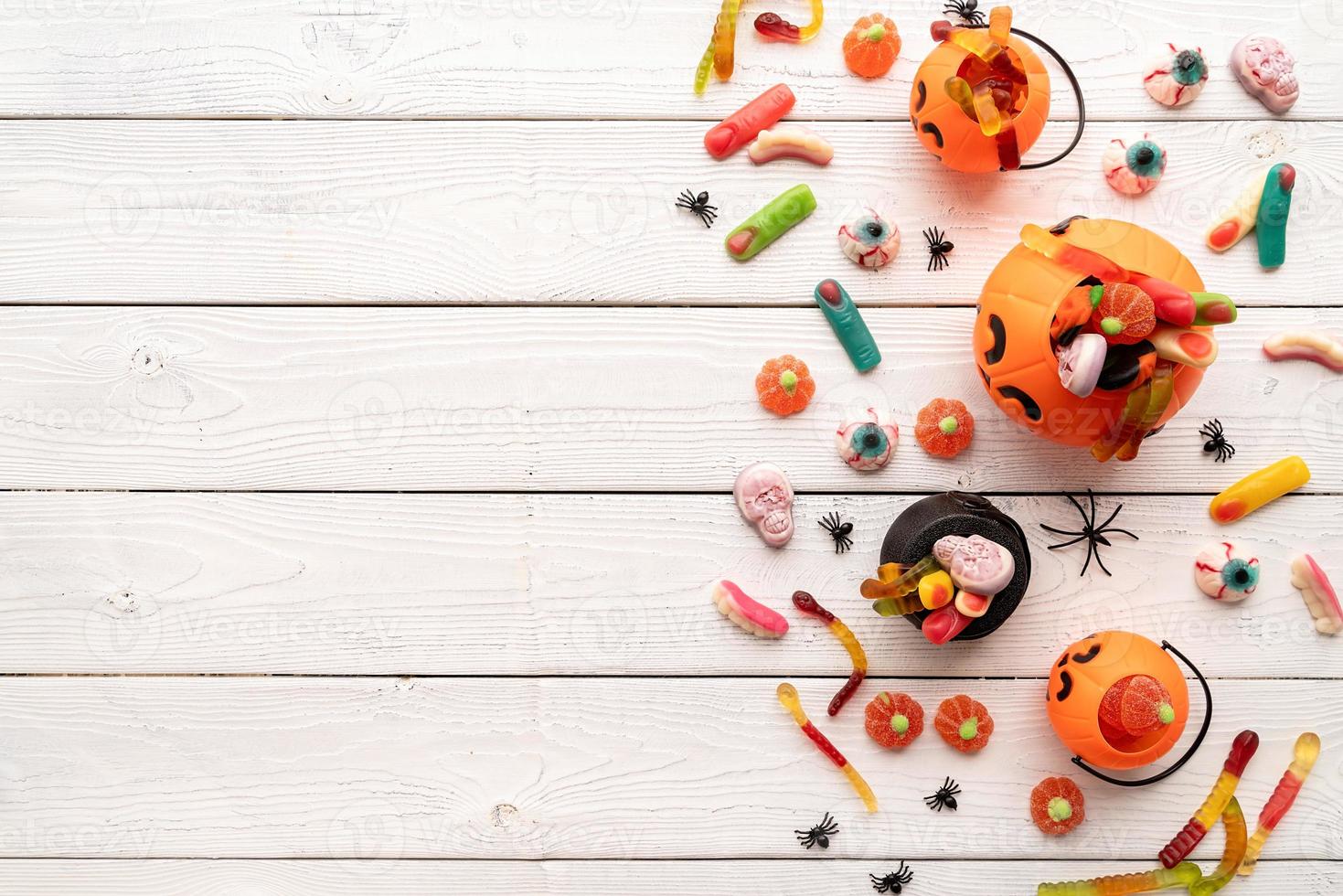 doces coloridos para festa de halloween em fundo branco de madeira foto