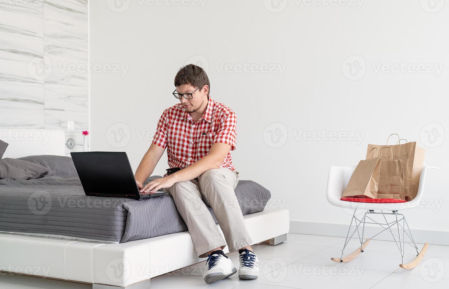 jovem fazendo compras na internet com laptop foto