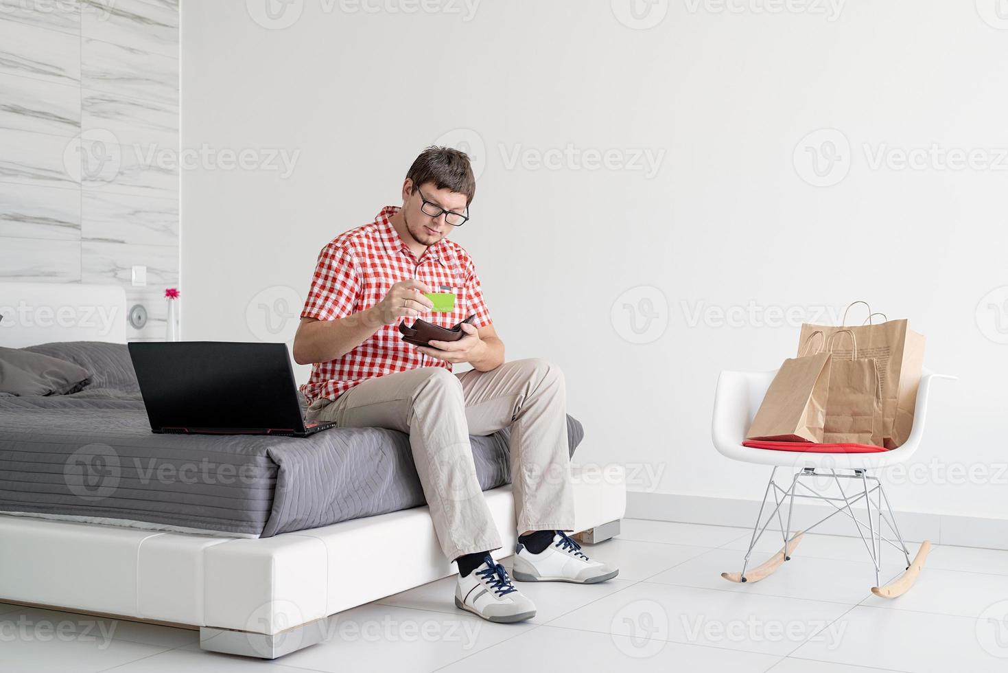 jovem fazendo compras na internet com laptop foto