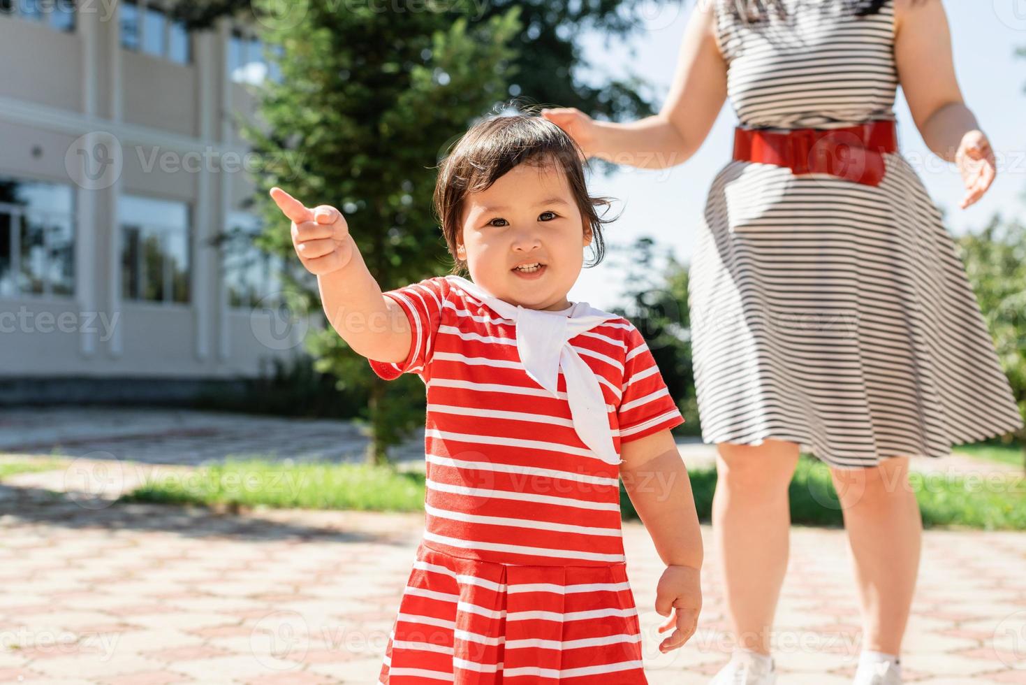 família multirracial feliz de mãe e filha caminhando no parque foto