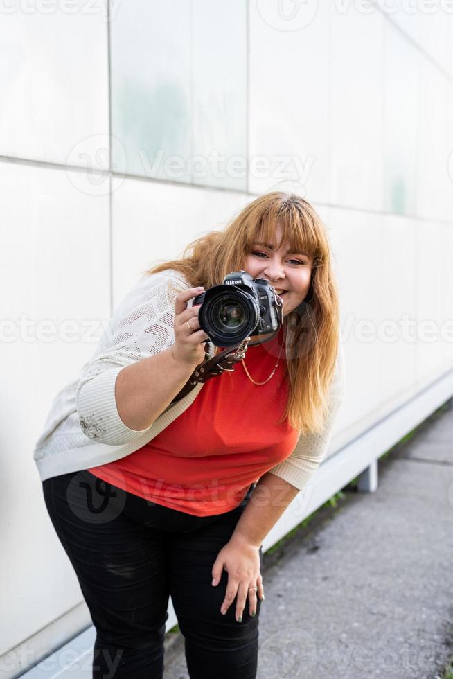 retrato de mulher obesa tirando fotos com uma câmera ao ar livre