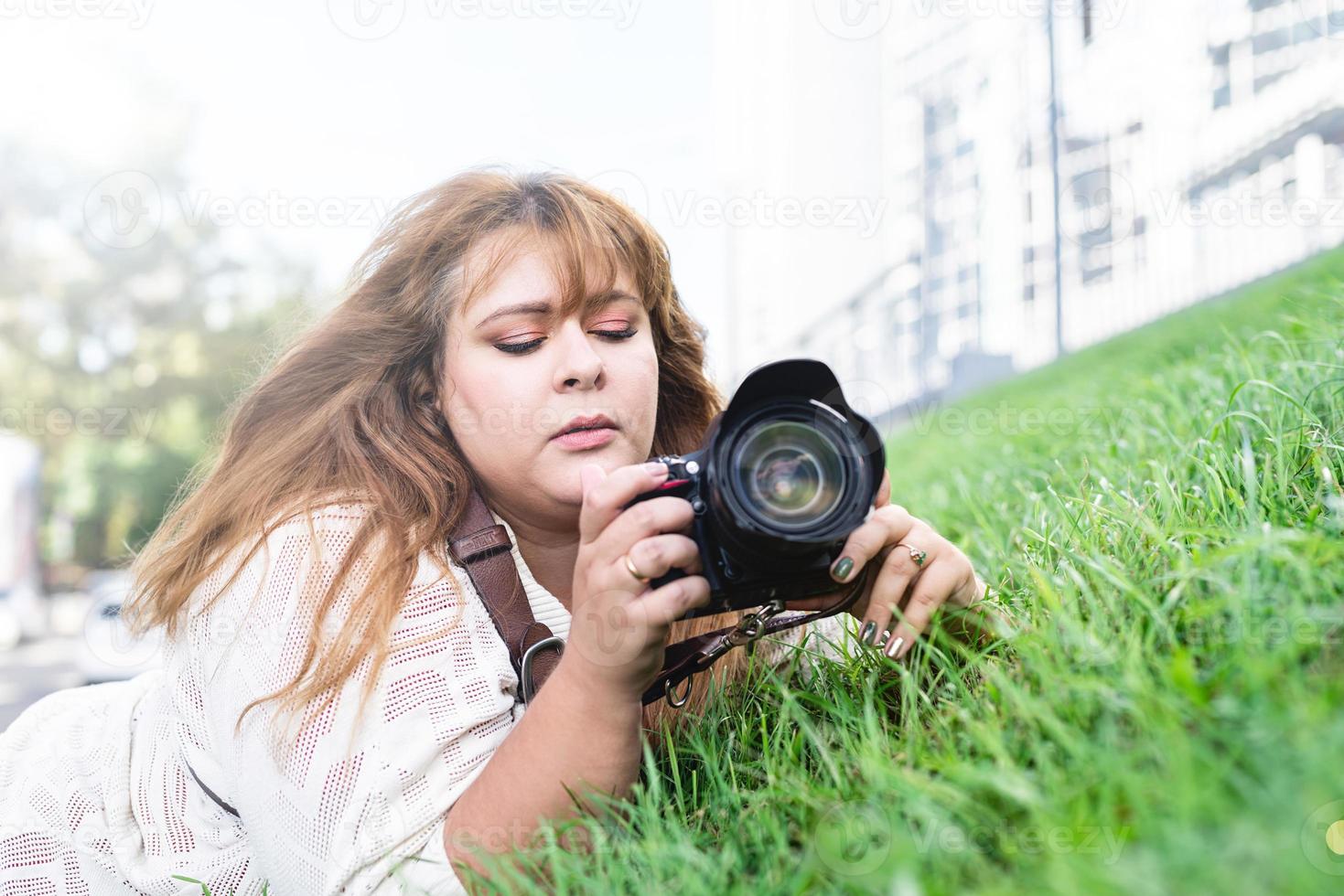 retrato de mulher obesa tirando fotos com uma câmera no parque