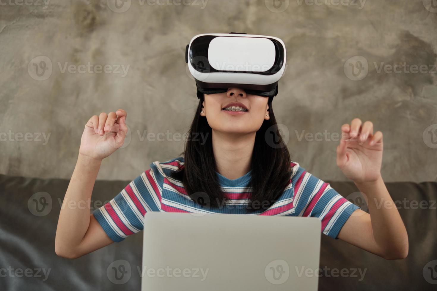 mulher asiática com fone de ouvido vr, assistindo a simulação virtual 3d. foto