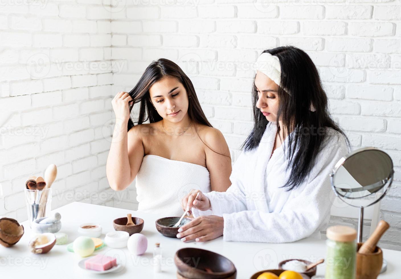 mãos femininas fazendo máscara facial realizando procedimentos de spa foto