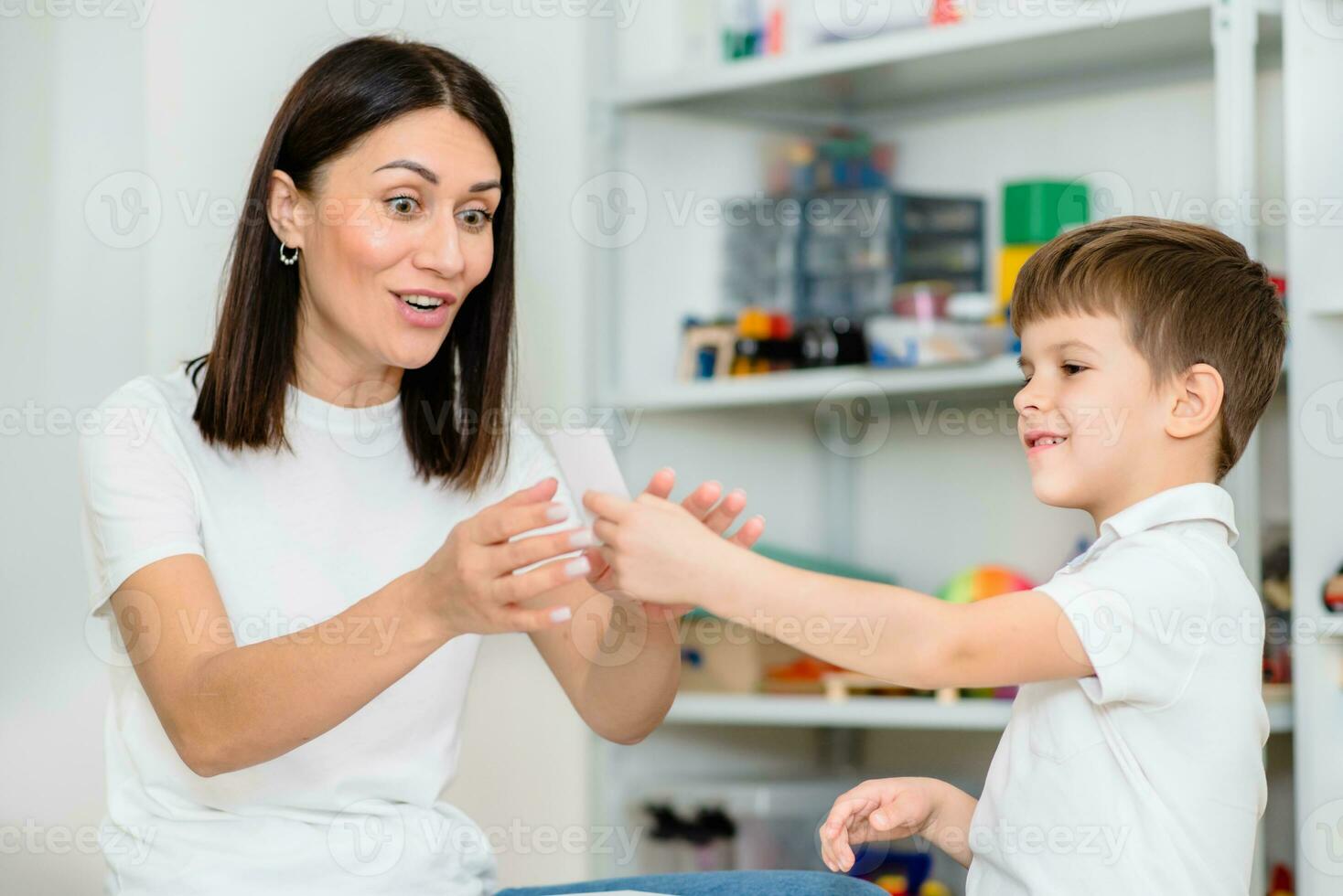 uma fofa criança com uma discurso terapeuta é ensinado para pronunciar a cartas, palavras e sons corretamente. foto