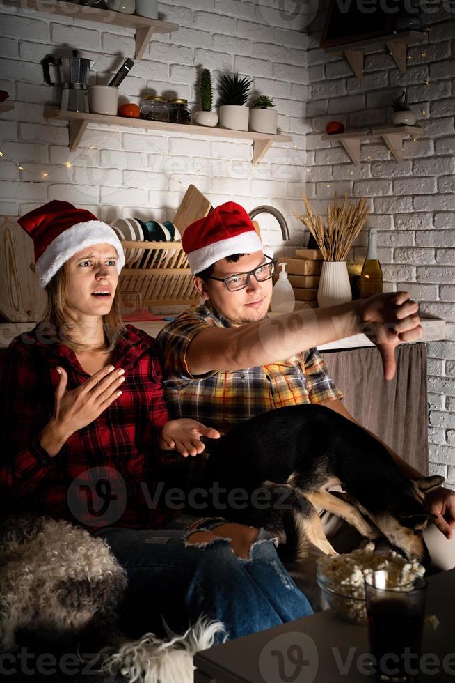 casal assistindo filmes em casa no natal apontando para a tela foto