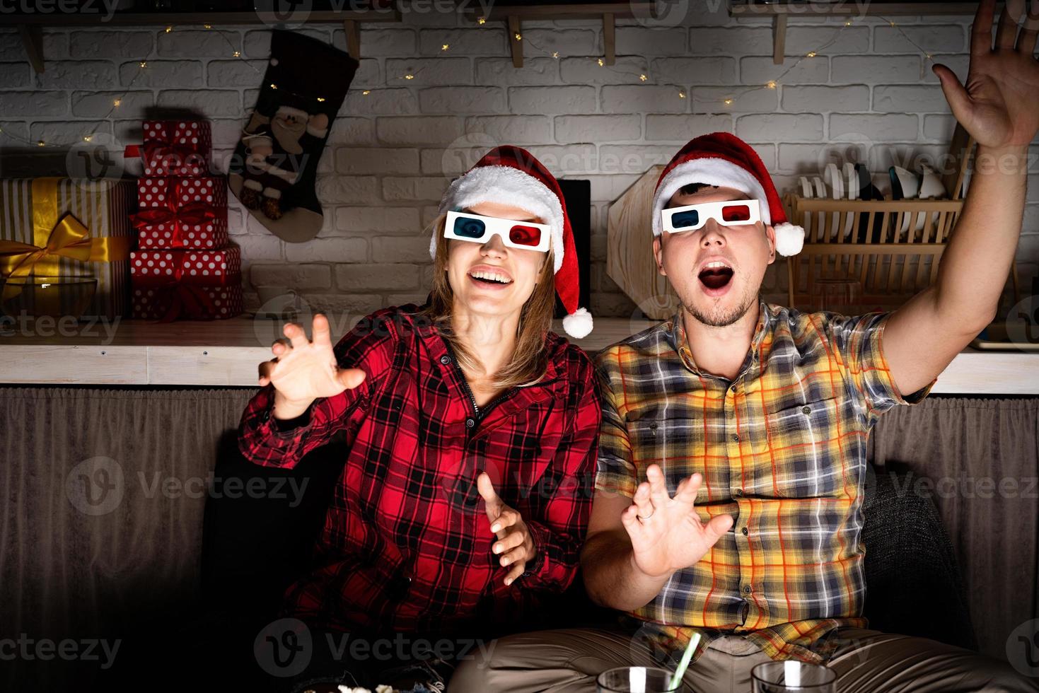 jovem casal em óculos 3D assistindo filmes em casa no natal foto