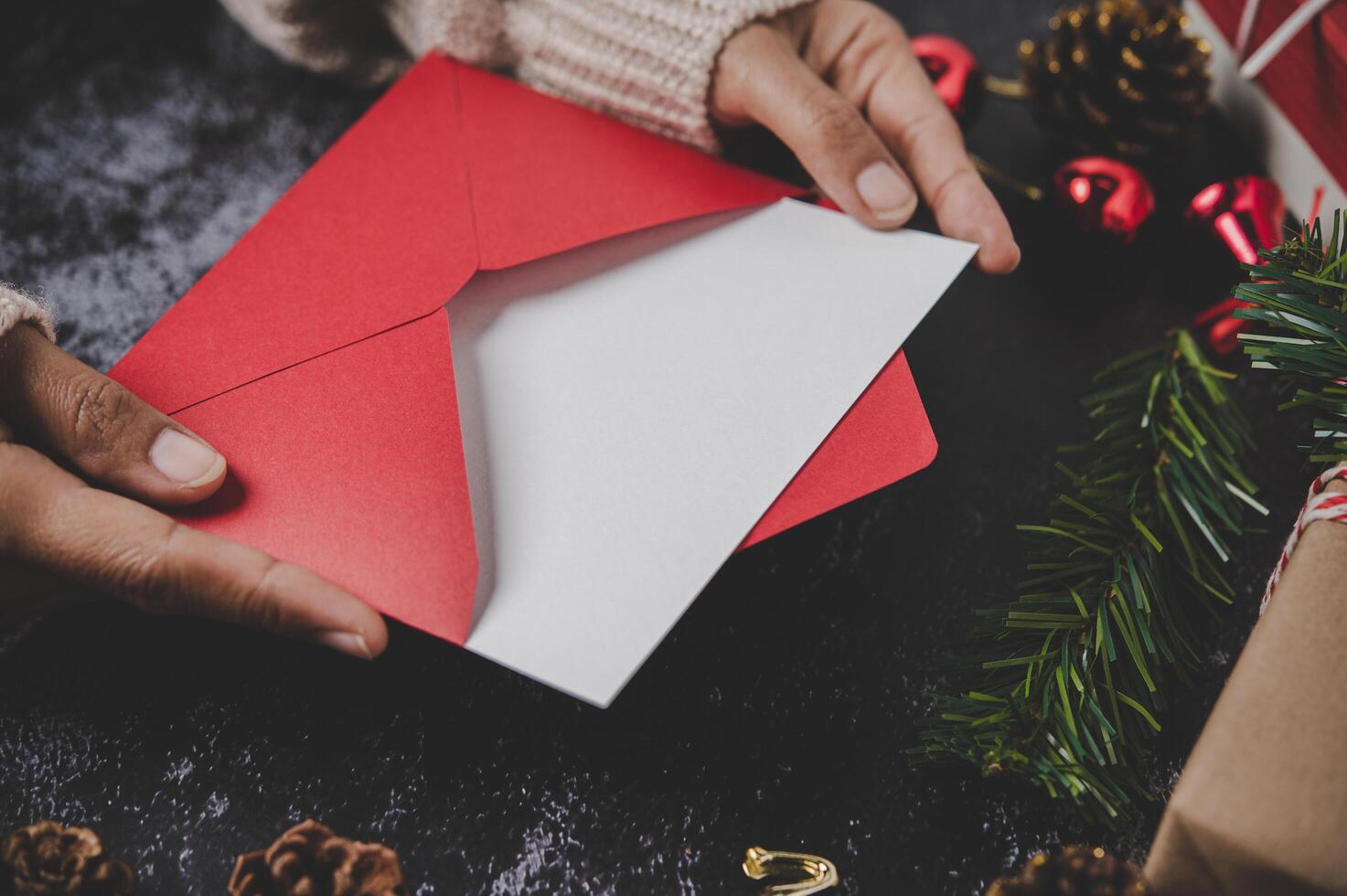 mãos segurando um cartão ou carta de natal aberta foto