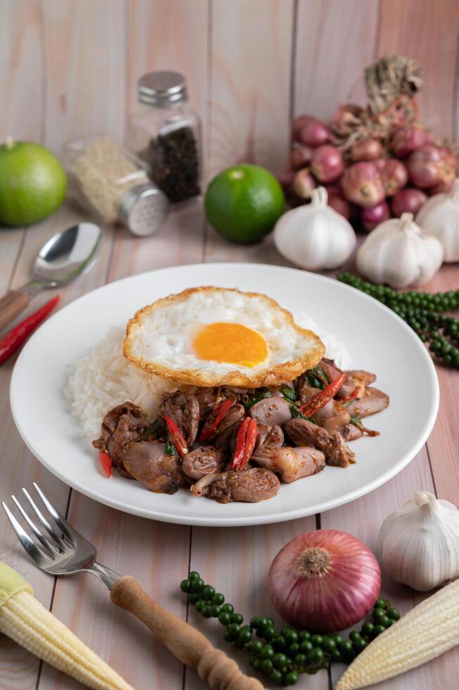 arroz frito de manjericão sagrado com coração de galinha e ovo frito foto