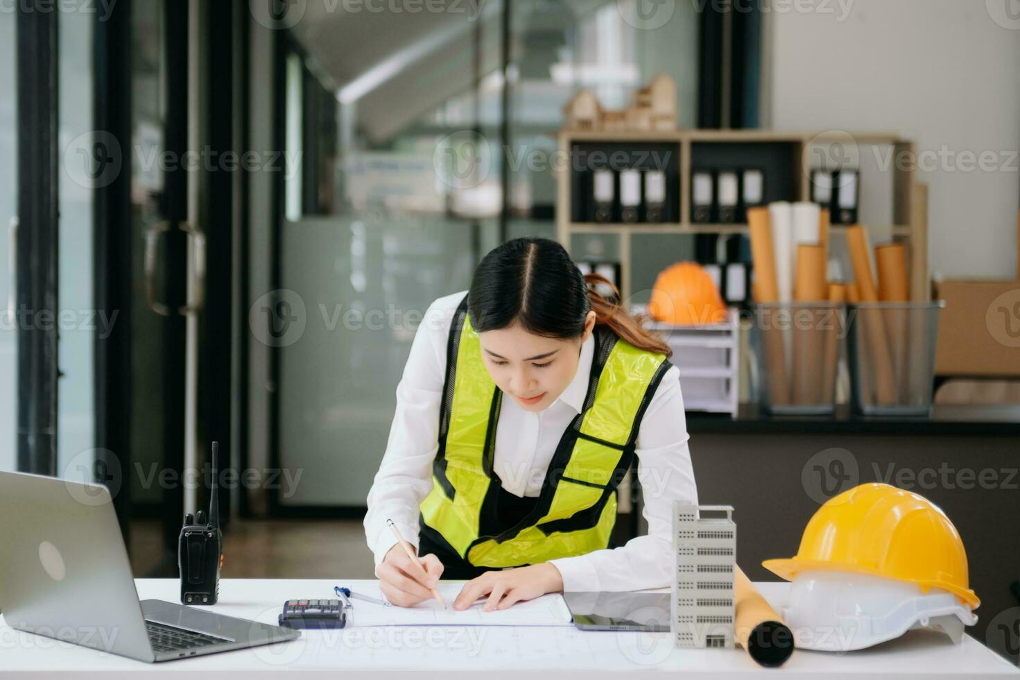 mão de mulher de negócios trabalhando e laptop com no projeto arquitetônico no canteiro de obras na mesa no escritório foto