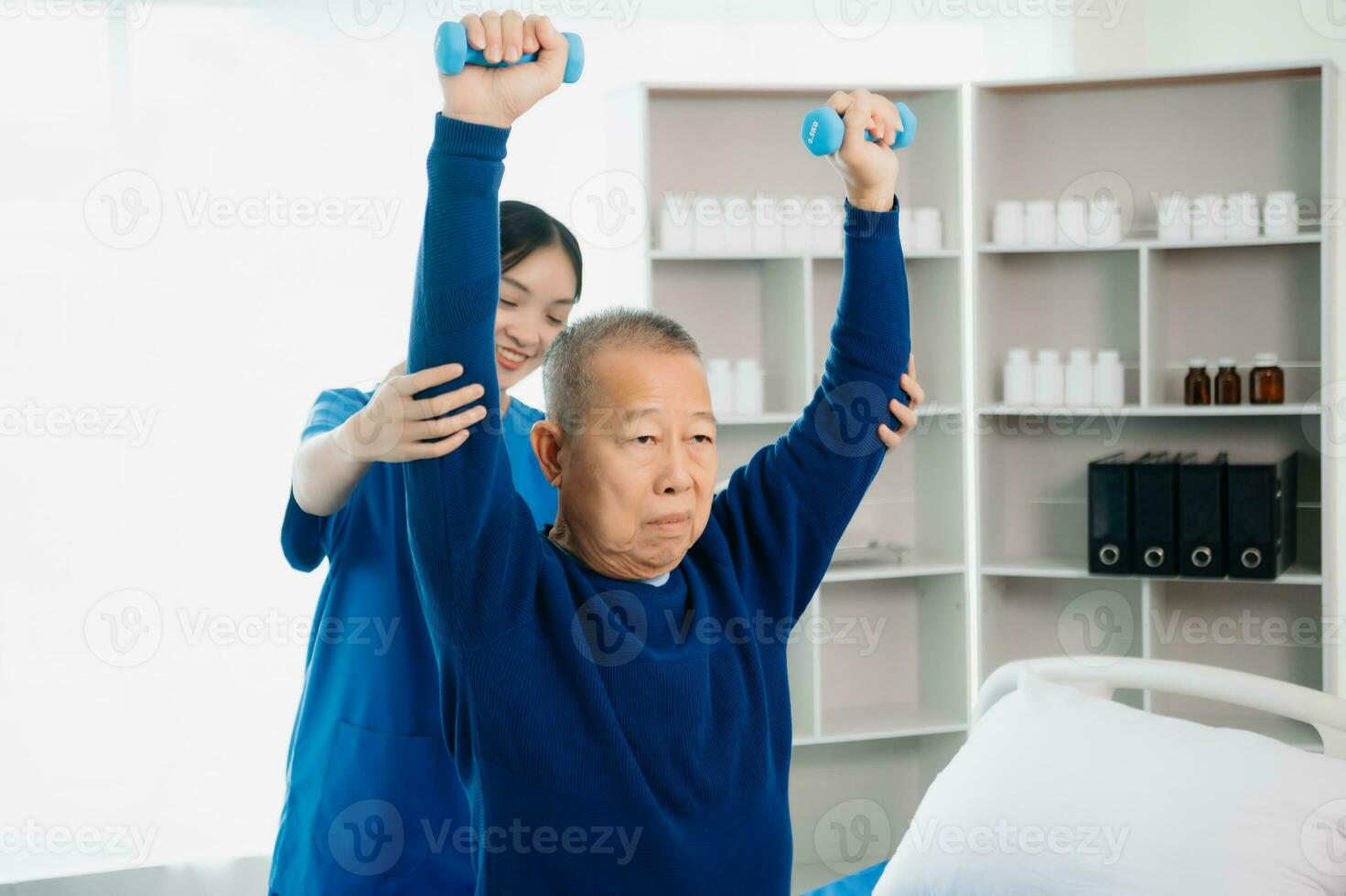 ásia fisioterapeuta ajudando idosos homem paciente alongamento braço durante exercício corrigir com haltere dentro mão durante Treinamento mão com paciente costas problemas foto