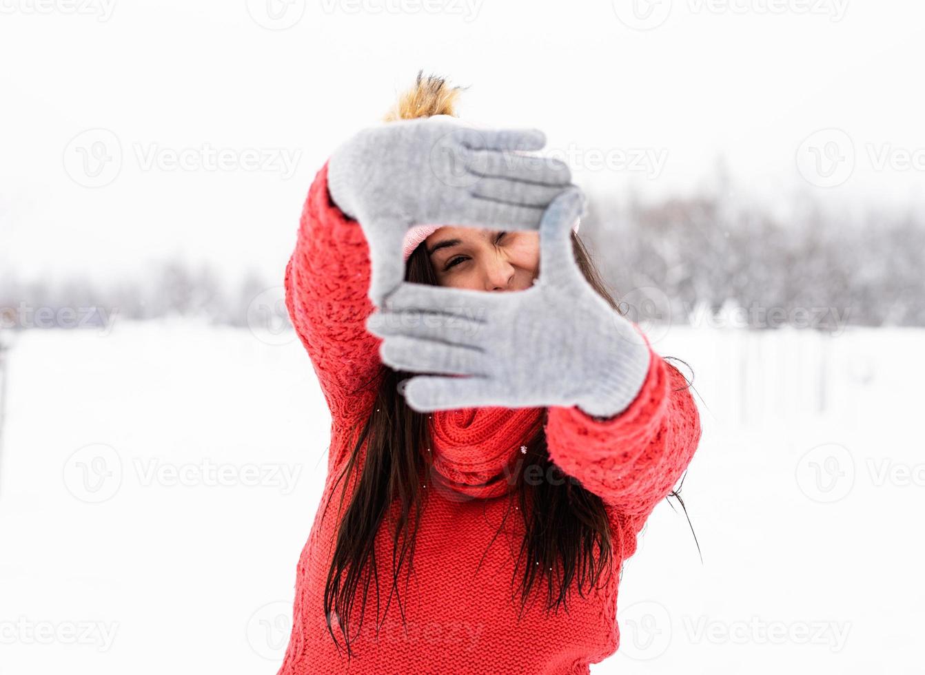 mulher fazendo quadro sinal com as mãos ao ar livre em dia de neve foto