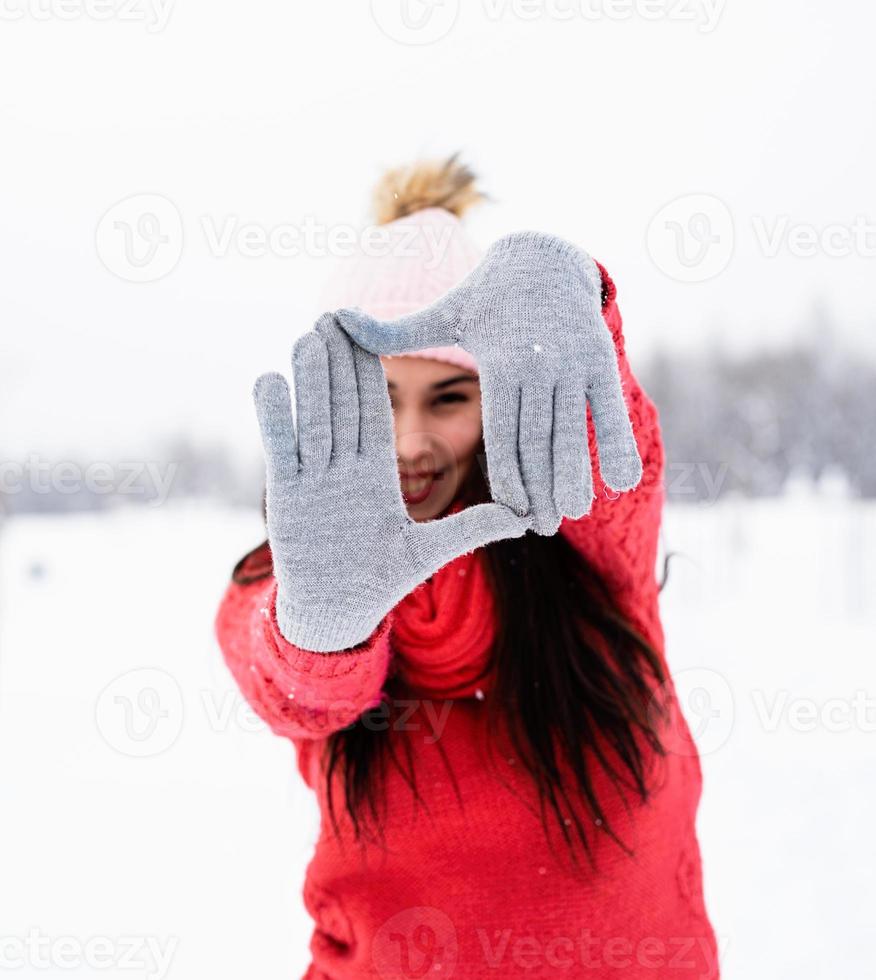 mulher com suéter vermelho fazendo sinal com as mãos foto