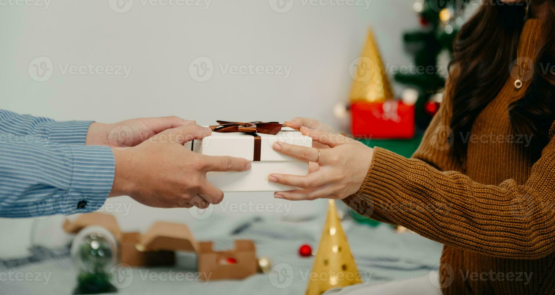 presente de natal nas mãos. homem feliz dando caixa de presente de natal e ano novo para mulher em casa. celebração de natal em família. Decoração de Natal. foto