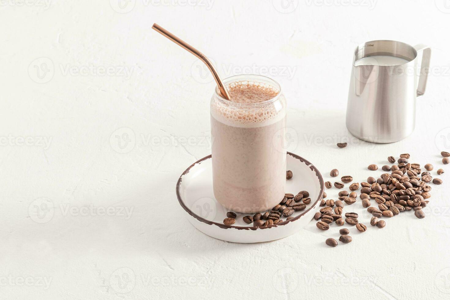 uma delicioso café capuccino, café com leite com espuma dentro uma moderno vidro dentro a Formato do uma Cerveja pode carrinhos em uma prato entre café feijões. branco fundo foto