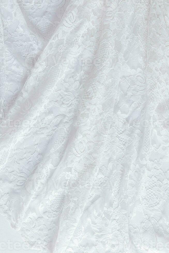 suave ondas do rendado branco tecido. parte do a da noiva vestir. Casamento renda com floral ornamento. linda Casamento fundo. foto