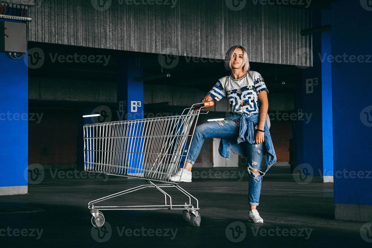 mulher com carrinhos de compras em um estacionamento foto