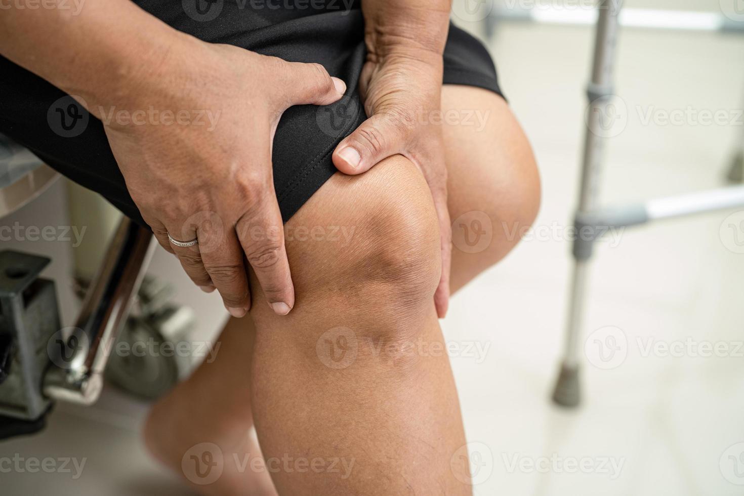 mulher segurando o joelho com dor foto